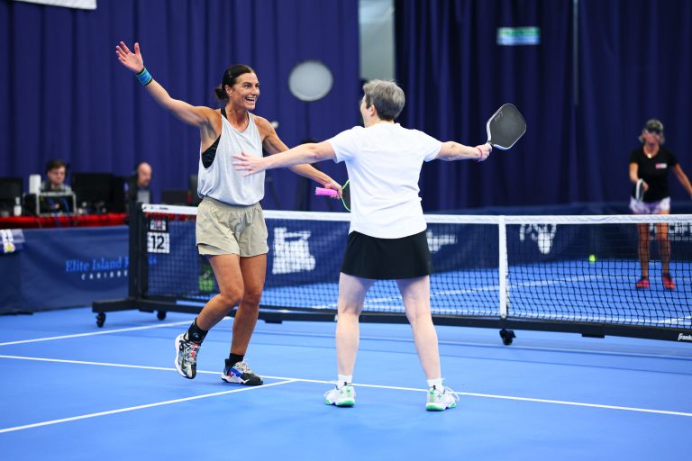 Two women doubles players celebrate on court at the English Nationals, Bolton Arena