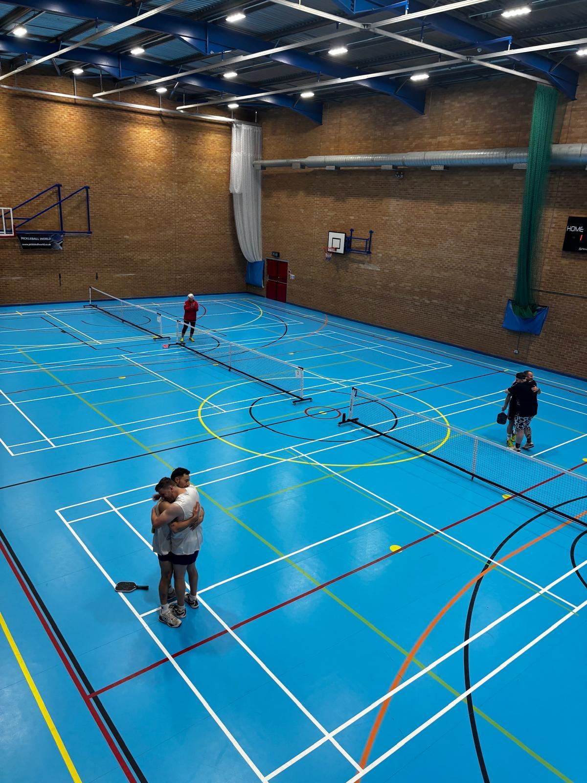 An indoor pickleball court seen from an elevated viewpoint