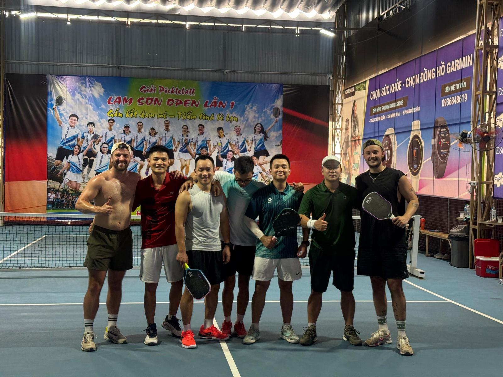 A group of players posing together on an indoor court