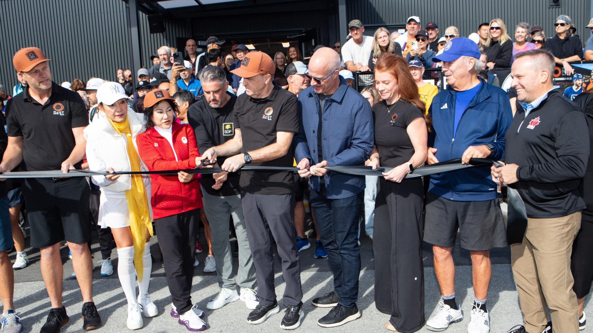 Officials and players cut the ribbon at the grand opening of The Nest indoor pickleball facility in British Columbia
